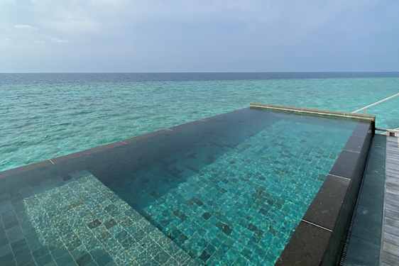 Pool der munder ud i turkisblåt hav