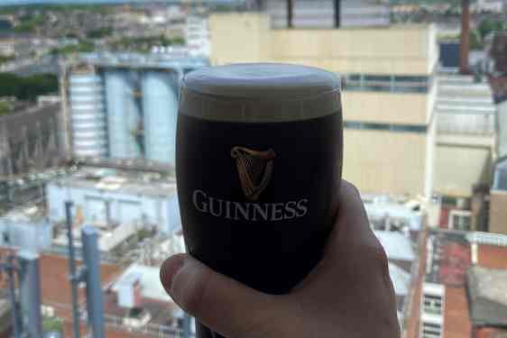 En hånd, som holder et glas Guinness.