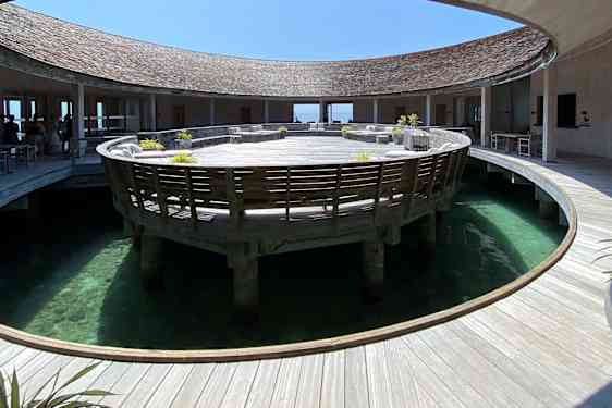 Rund træbygning med rund åbning ned til havet i midten