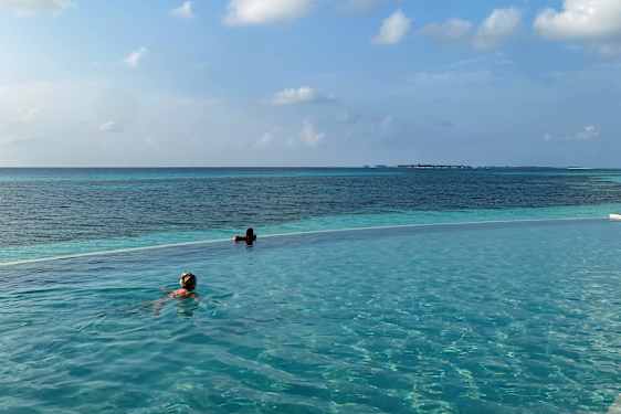 To personer svømmer i en infinitypool