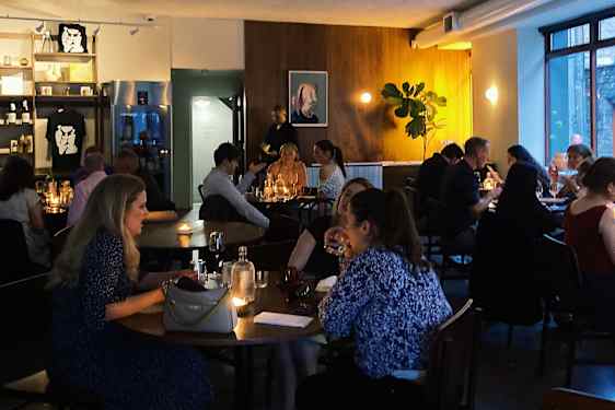 Folk sidder ved vorde på en restaurant i dæmpet belysning