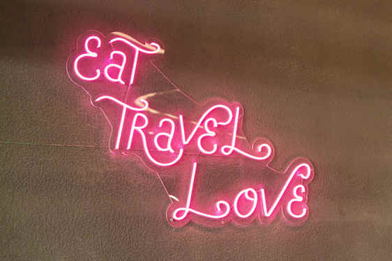 Neonskilt med teksten Eat, Travel, Love