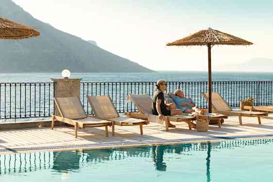 Par ligger ved poolen på deres voksenhotel