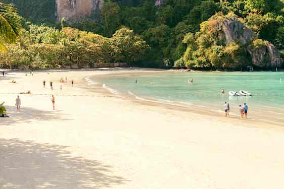 Strand med mennesker på badeferie i Thailand