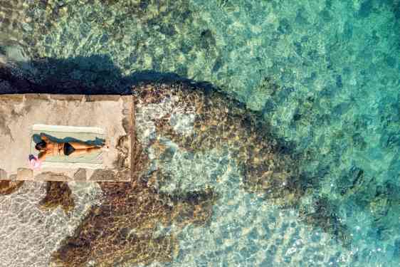 Kvinde ligger ved vandet i Kroatien