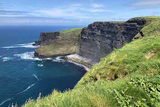 Cliffs of Moher – grønne klipper ved et blåt hav.