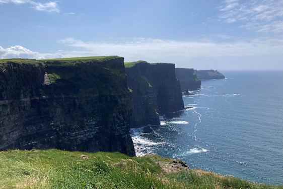 Cliffs of Moher – grønne klipper ved et blåt hav.