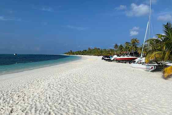 Både på kridhvidt sand, turkisblåt hav og palmer