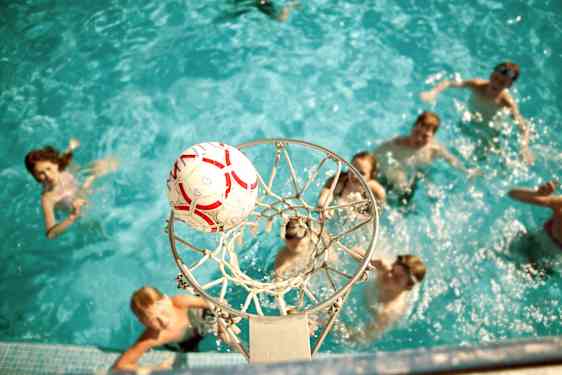 Unge gæster spiller basket i pool på Family Garden