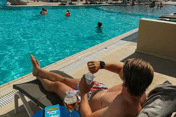 Mand ligger ved poolen