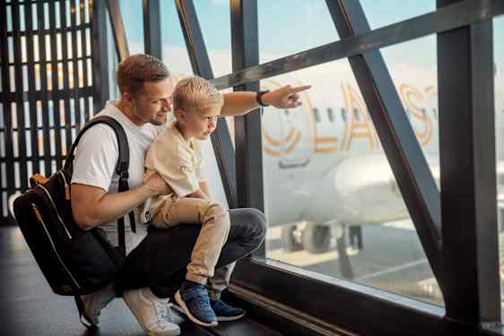 Pappa och son tittar ut över ett flygplan