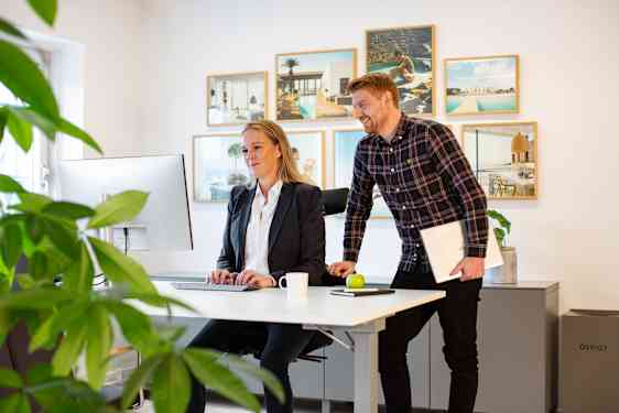 To personer står og ser på en computerskærm