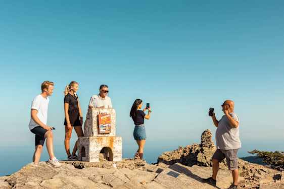 Et selskab tager et billede på toppen af et bjerg