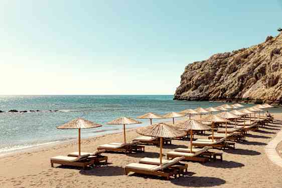 Strand på Rhodos med liggestole og parasoller