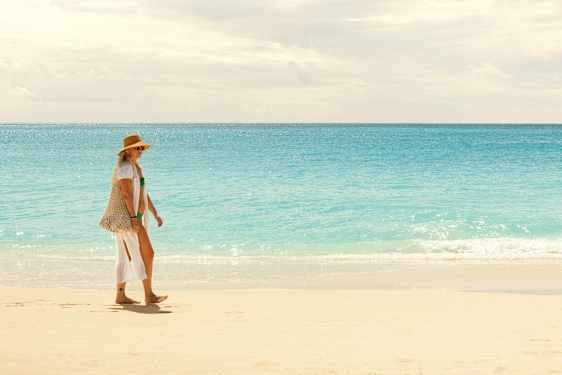 Kvinde går på stranden i Aruba