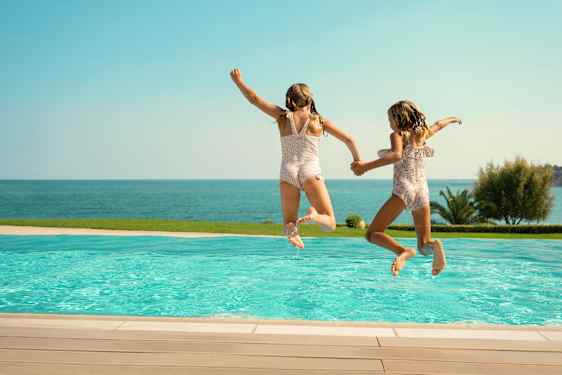To piger hopper i poolen