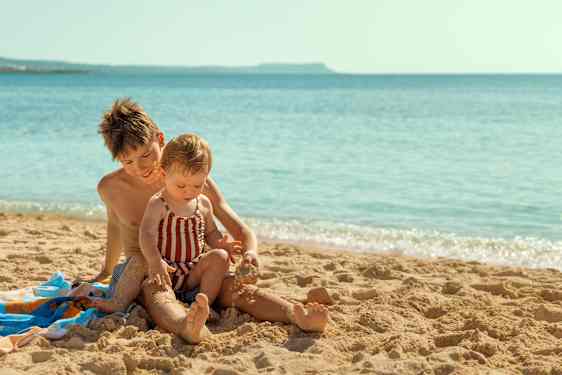 Bror og søster leger i sandet