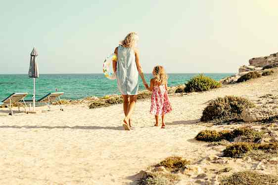 Mor og datter går ved stranden