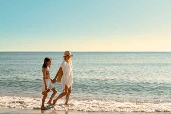 Mor og datter går tur på stranden