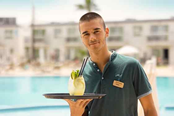 Bartender med drink ved poolen