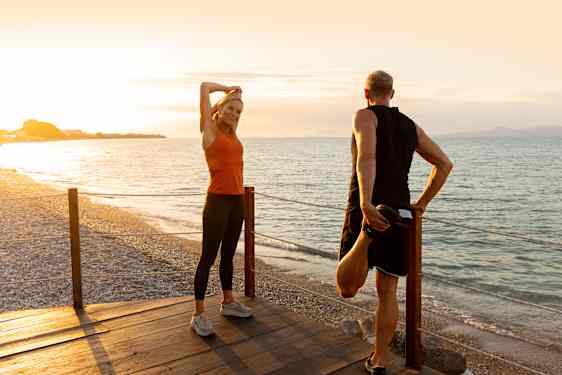 Par står og strækker ud ved stranden - træningsrejser fra Spies