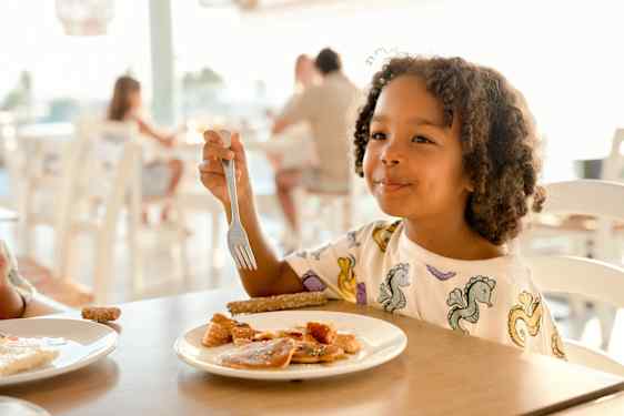 Pige spiser mad i restaurant
