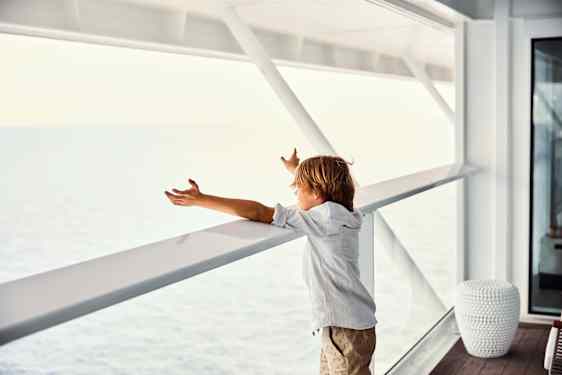 Barn ser ud over havet fra vindue på Celebrity Cruises