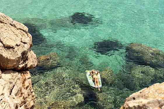 kvinde ligger på bademadras i vandet