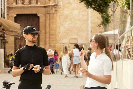 To personer, som spiser is ved siden af sine cykler.