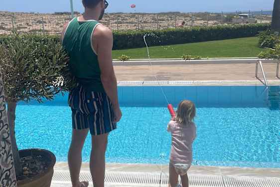 Onkel og niece skyder med vandpistol.