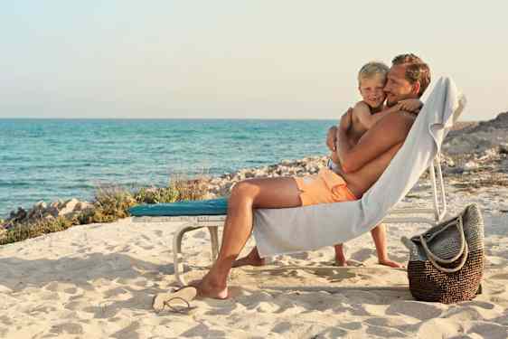 Far og søn hygger på stranden