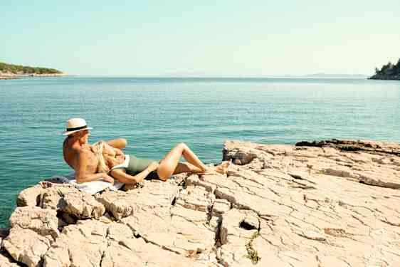 Par ligger på klippe i Kroatien