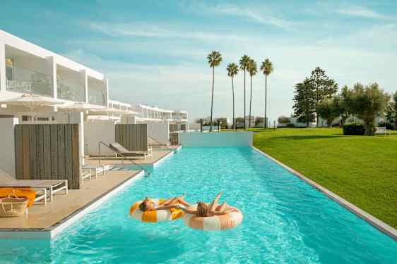 To piger ligger i baderinge i pool