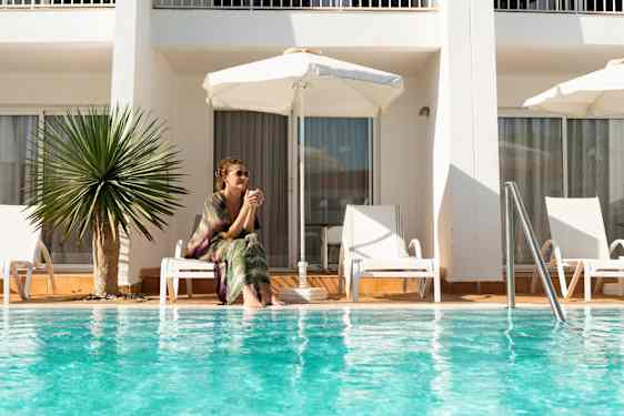 kvinde sidder ved pool