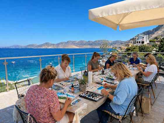 Gruppe af kvinder der sidder og maler