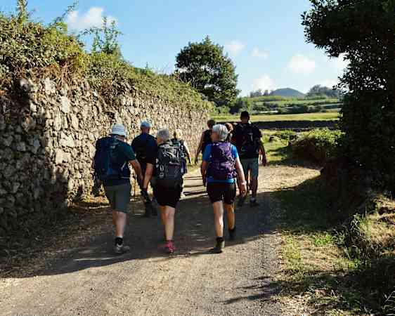 Group of hikers walking along stonewall