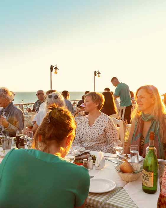En gruppe spiser middag på en udendørs restaurant