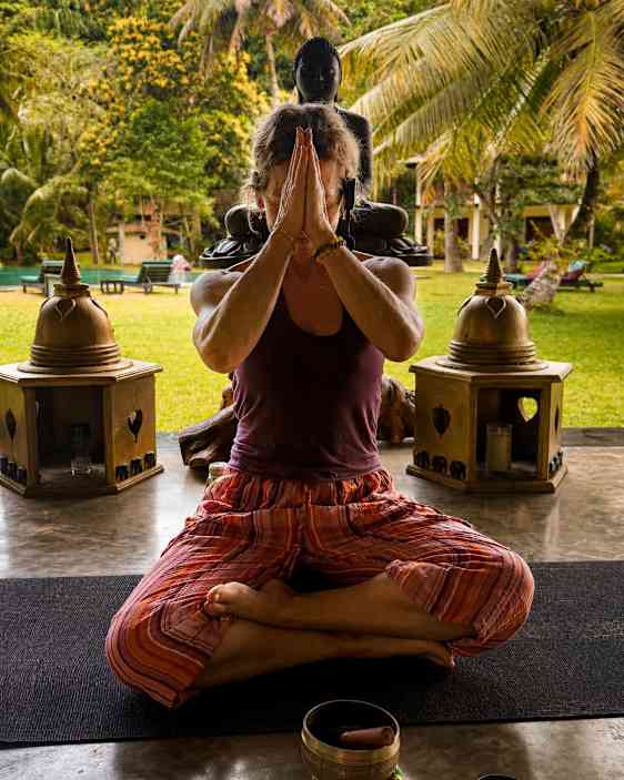 Yogalæren siddende på gulvet
