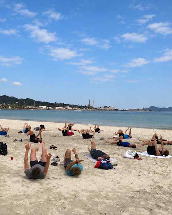Deltagere laver core træning på stranden.