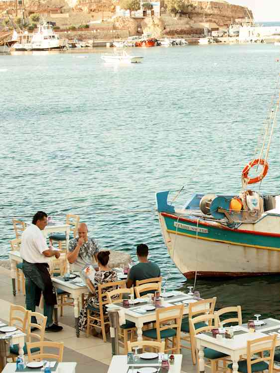 Restaurant ved havet med fiskebåd i vandet