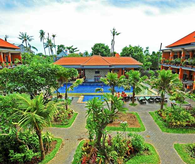 Hotellets anlæg med tropisk have og pool. (AI-genereret tekst)