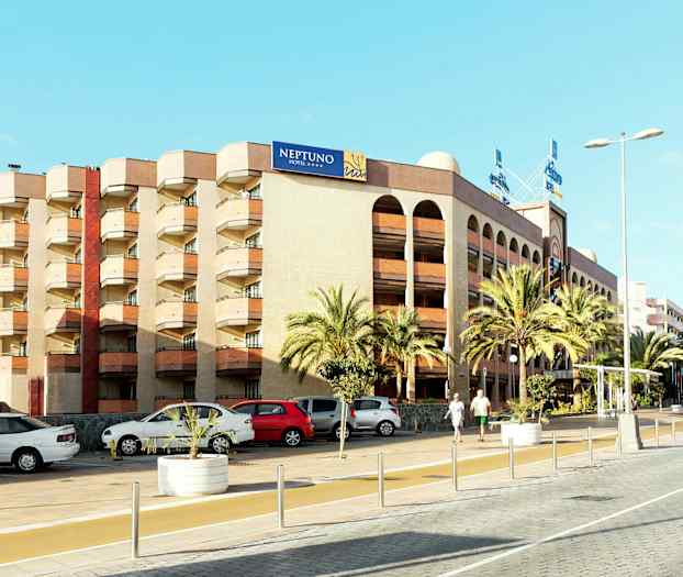 En flerfarvet bygning med et skilt med teksten "NEPTUNO HOTEL", omgivet af palmer og parkerede biler. (AI-genereret tekst)