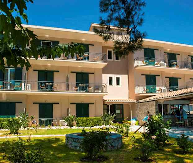 Udvendigt billede af et treetagers boligkompleks med altaner og omkringliggende have. (AI-genereret tekst)