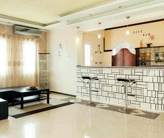 Et rum med bar og siddeområde. (AI-genereret tekst)