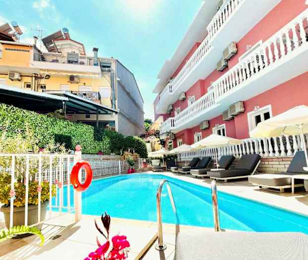 Udendørs pool ved et hotel med liggestole og parasoller. (AI-genereret tekst)