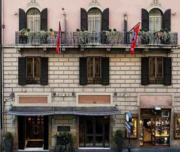 Bygningen har en klassisk facade med altaner og blomsterkasser. (AI-genereret tekst)