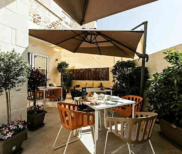 En terrasse med udendørsmøbler, parasoller og planter. (AI-genereret tekst)