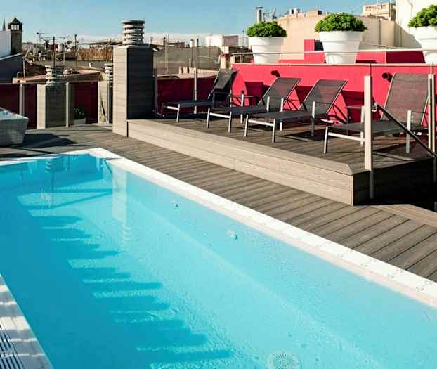 Tagpool omgivet af trædæk og liggestole, med udsigt over bymiljø. (AI-genereret tekst)