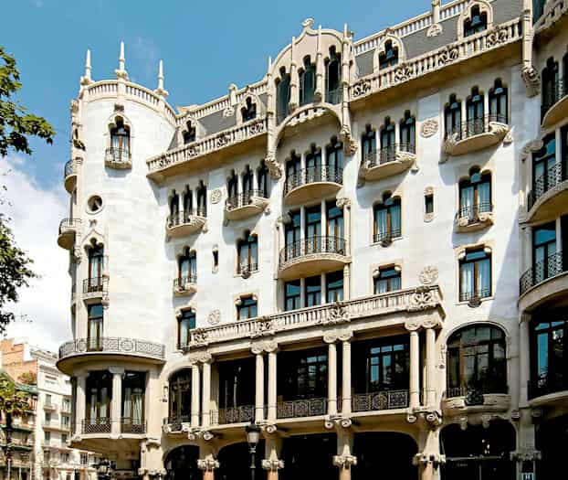 Et billede af en dekorativ bygning med udsmykket facade, altaner og buede vinduer. (AI-genereret tekst)