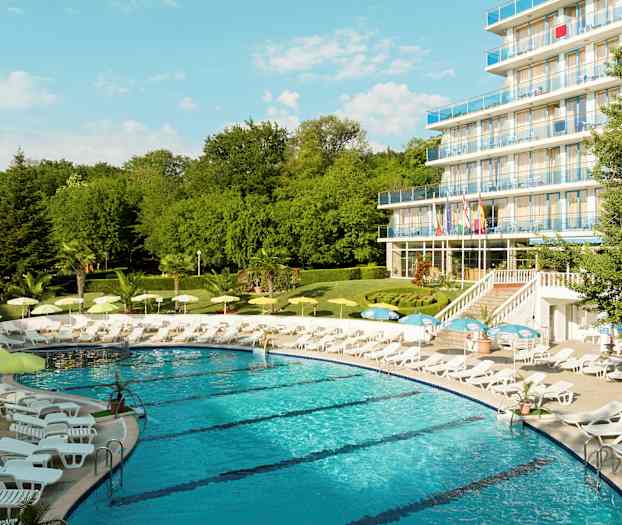 En pool omgivet af liggestole og parasoller nær et hotel med flere etager. (AI-genereret tekst)